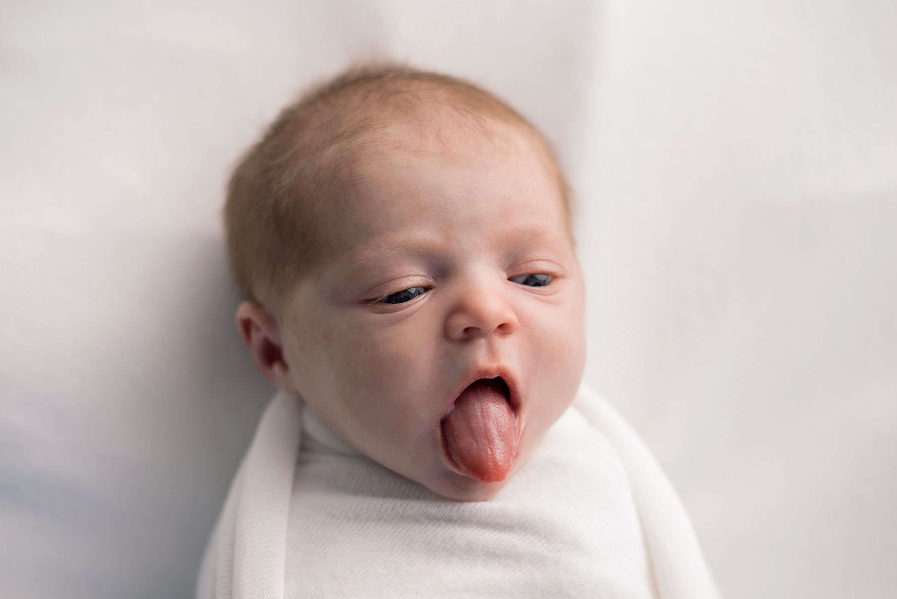 Newborn baby sticking out tongue